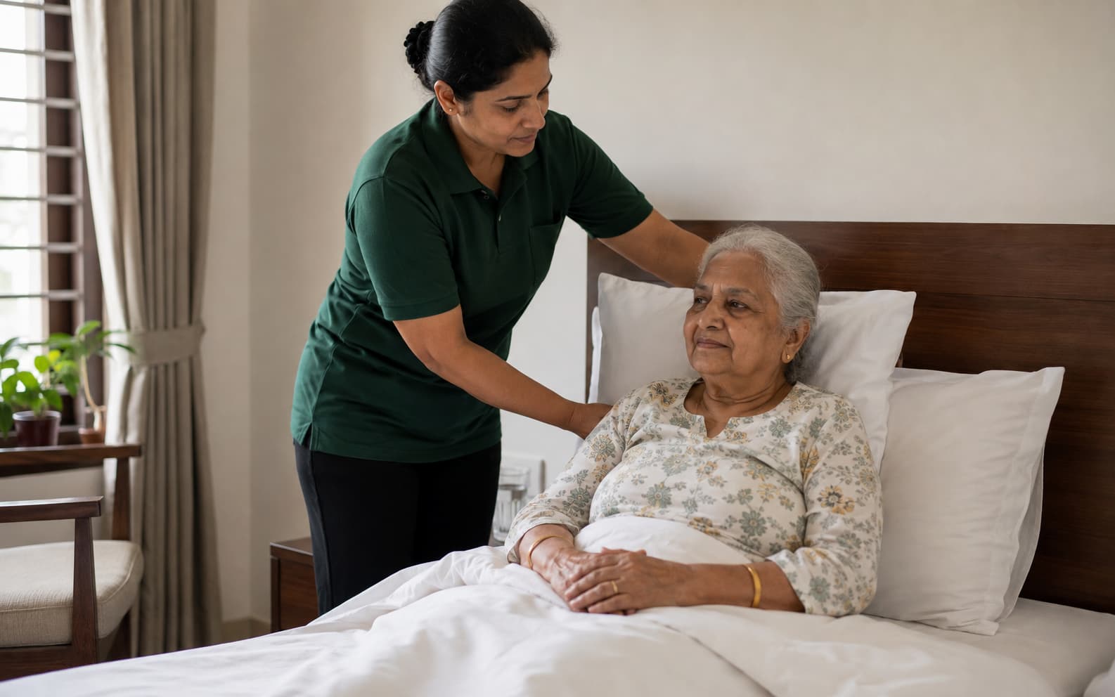 Caregiver adjusting pillows for a bedridden elderly woman at home