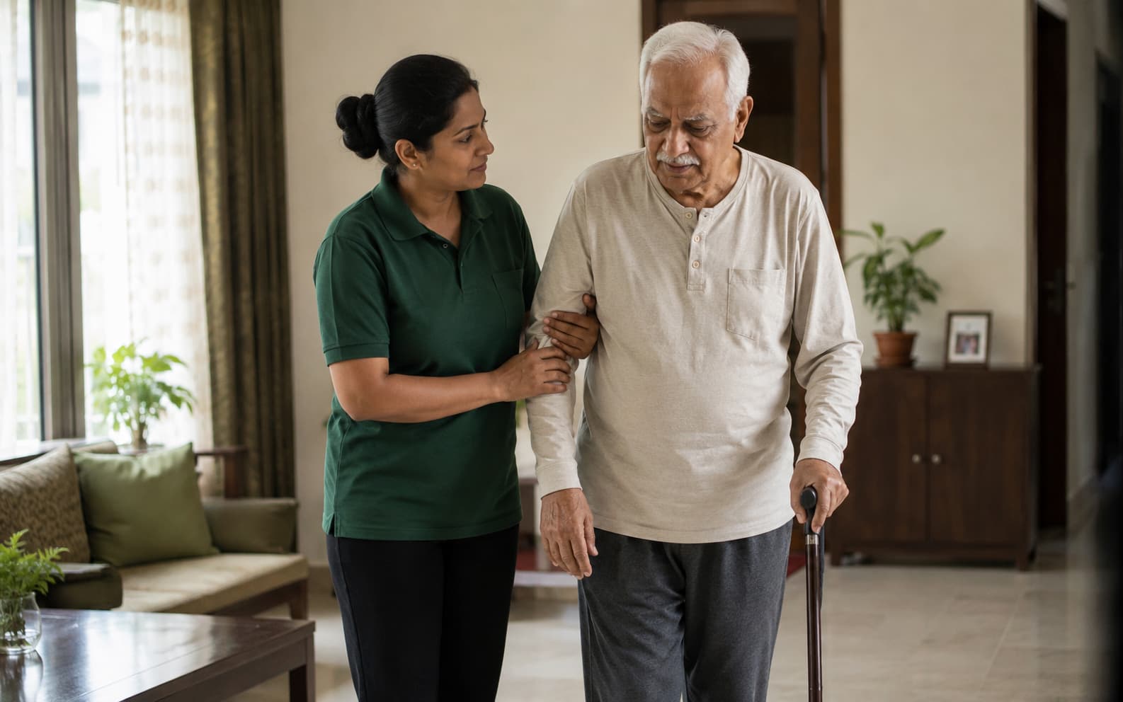 Caregiver supporting an elderly man as he walks at home